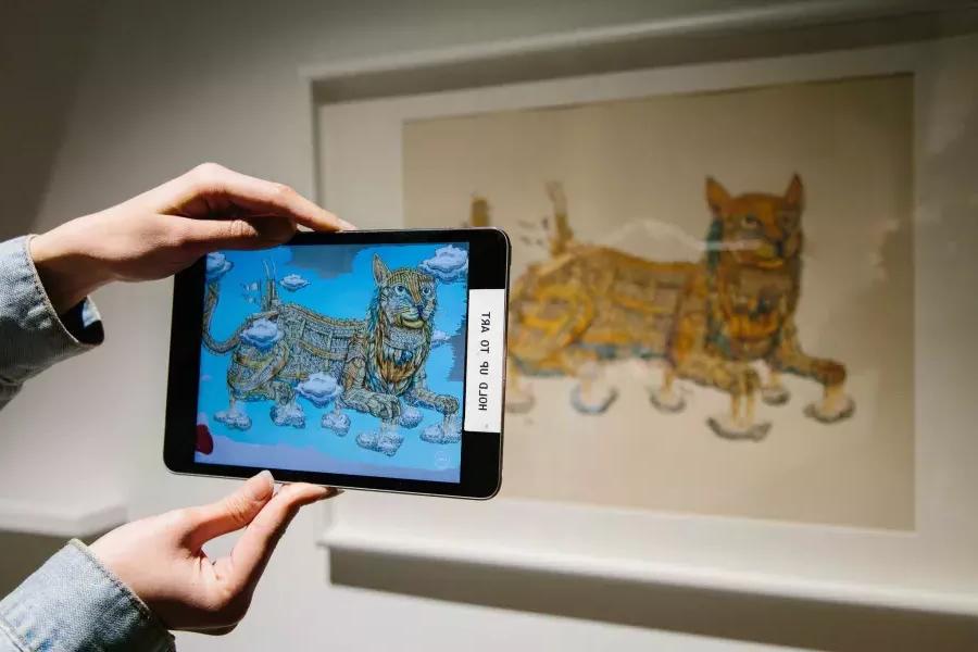 Holding iPad up to art.