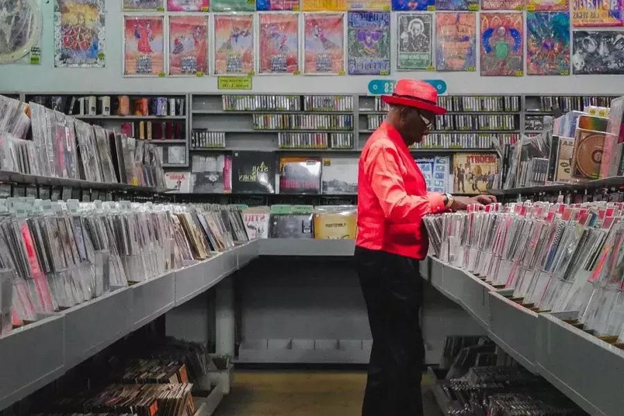 Un homme en veste rouge achète des disques chez Amoeba Records à San Francisco.