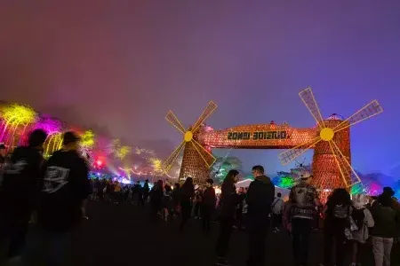 一群参加音乐节的人在夜晚的霓虹灯下参加了贝博体彩app的“外域”音乐节.