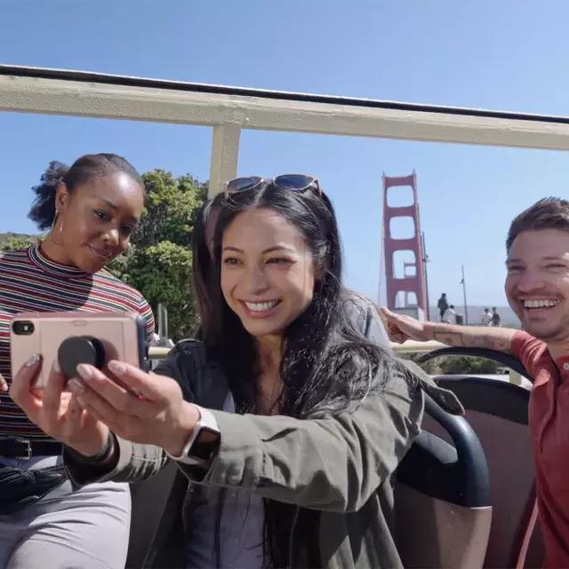 A group of visitors take a selfie on a bus tour near the Golden Gate Bridge. San Francisco, CA.