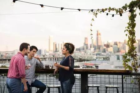三个人聚集在一个广告牌表的屋顶甲板锚蒸馏在贝博体彩app, 加利福尼亚.