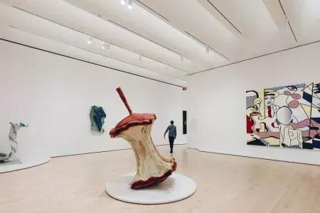 在贝博体彩app现代艺术博物馆，一个男人走过一个充满现代艺术的大而活泼的展厅. 贝博体彩app，加利福尼亚.